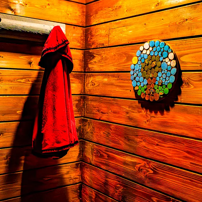 Red towel hanging on a warm wooden wall beside a circular mosaic made of colored pencils. | Escape Code | Branson, Missouri Escape Room